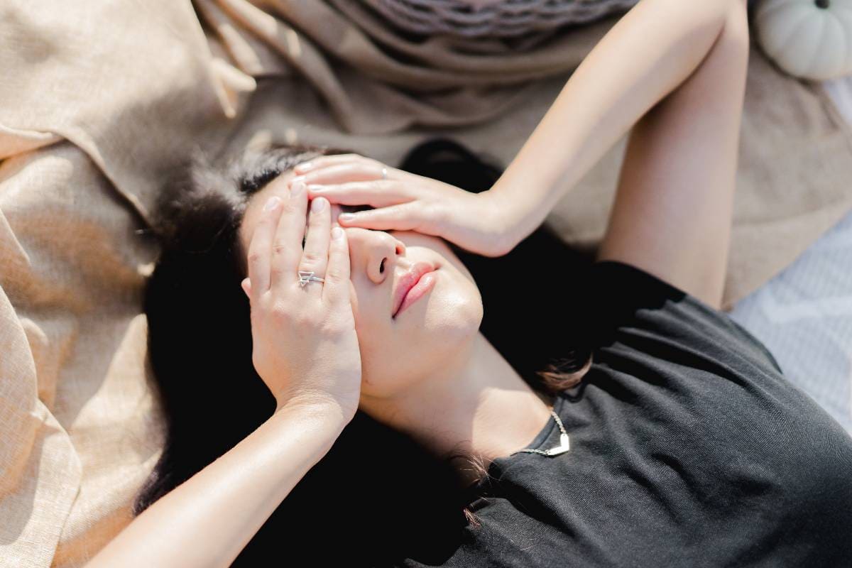 girl covering up her eye laying on the ground