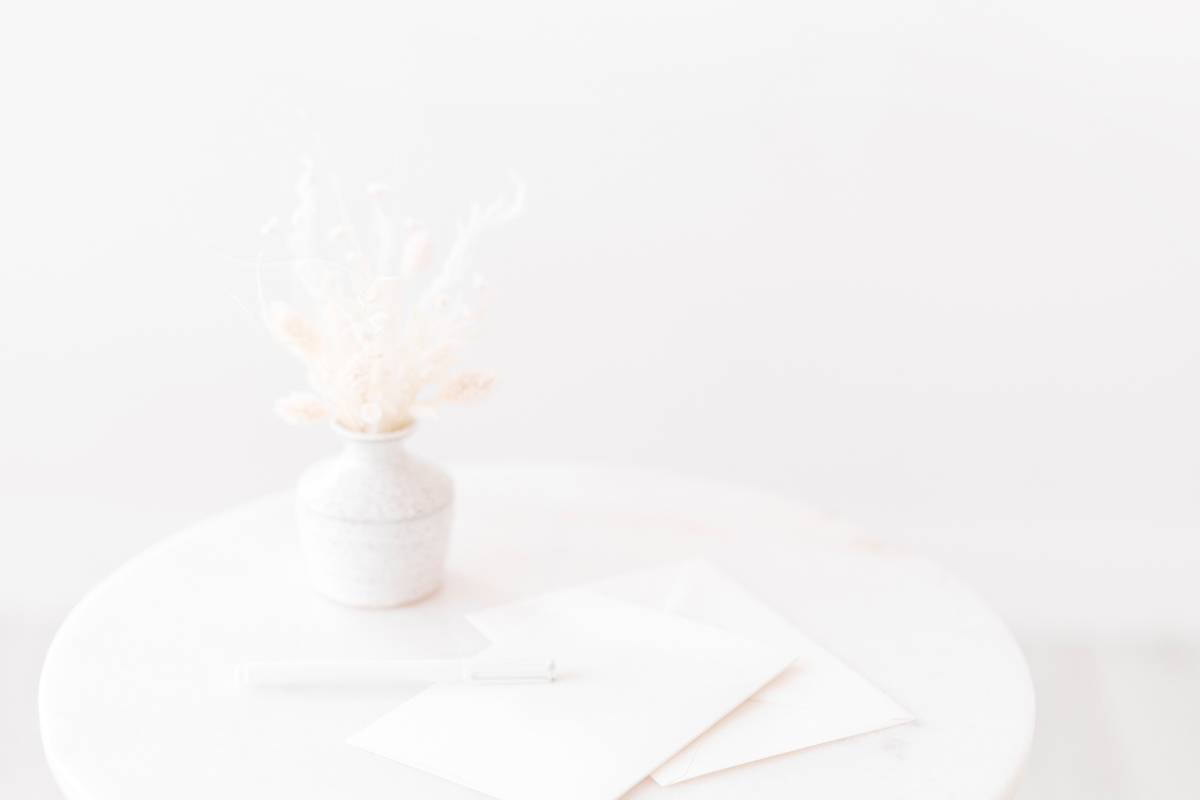 white flowers in a white vase on a white table with white paper (lots of white)