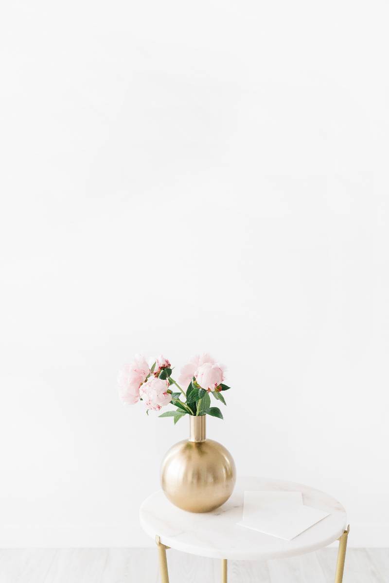 pink roses in a gold vase on a white background